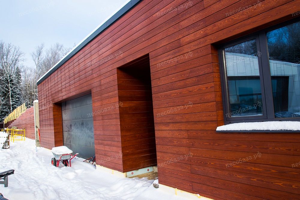 Фасад гаража обшитый скошенным планкеном из лиственницы